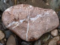 Rötlicher Stein mit weißer Kreuzmaserung